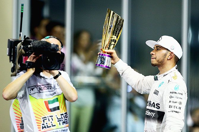 Mercedes GP's British driver Lewis Hamilton lifts his trophy on the podium after finishing second in the Abu Dhabi Formula One Grand Prix