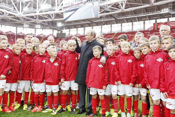 Russian President Vladimir Putin talks to young soccer players during a visit to Spartak's stadium Otkrytie Arena in Moscow