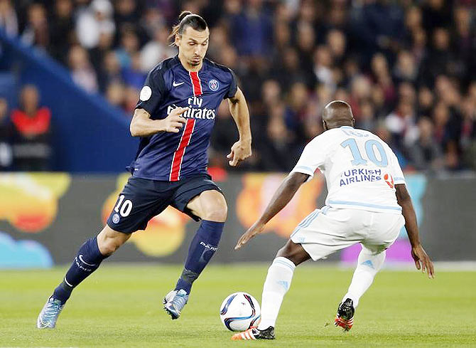 Paris St Germain's Zlatan Ibrahimovic (left) challenges Olympique Marseille's Lassana Diarra during their French Ligue 1 match at the Parc des Princes stadium in Paris, France, on Sunday