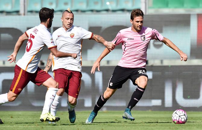 Palermo's Franco Vazquez (right) is challenged by AS Roma's Radja Nainggolan (centre) and Miralem Pjanic during their Serie A match at Stadio Renzo Barbera in Palermo, on Sunday
