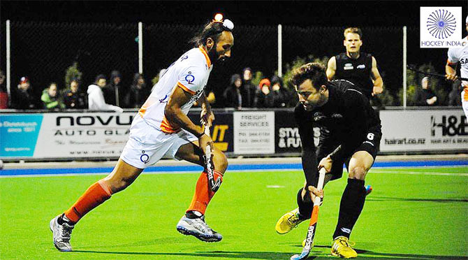 India captain Sardar Singh is blocked by a Kiwi defender