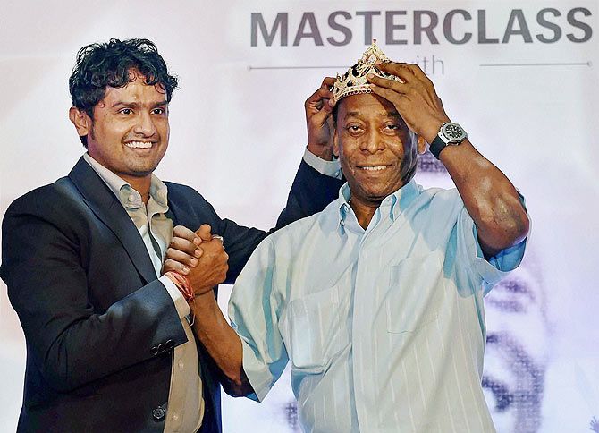 Indian footballer Dipendu Biswas presents a crown to legendary Brazilian footballer Pele during a promotional event in Kolkata on Tuesday