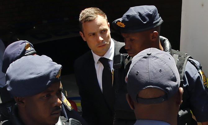 Oscar Pistorius (centre) is escorted to a police van after his sentencing at the North Gauteng High Court in Pretoria