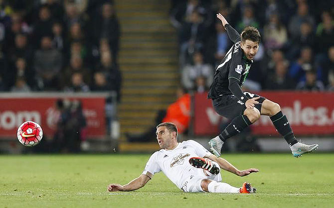 Swansea's Angel Rangel challenges Stoke's Bojan Krkic (right)