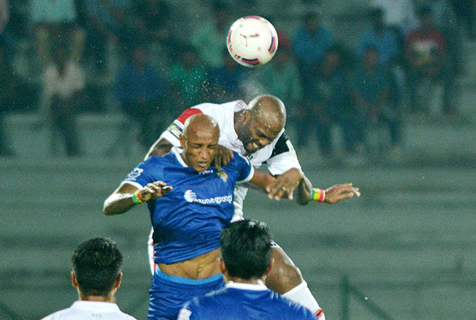 North East United FC (white) and Chennaiyan FC players vie for the ball 
