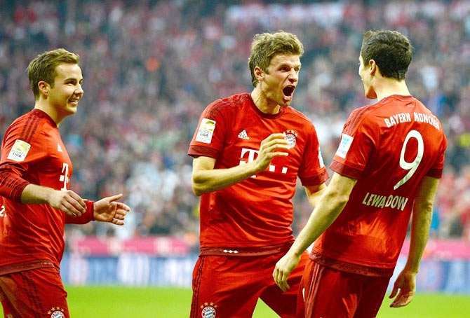Bayern Munich's Robert Lewandowski (right) celebrates with teammates Thomas Mueller (centre) and Mario Goetze