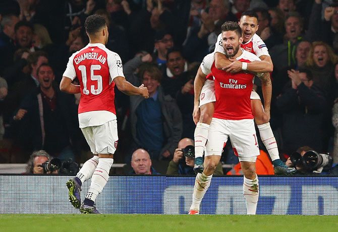 Arsenal's Olivier Giroud (centre) celebrates with Alex Oxlade-Chamberlain (15) and Alexis Sanchez after scoring their first goal against Bayern Munich during their UEFA Champions League Group F match at Emirates Stadium in London on Tuesday