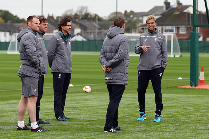 Liverpool manager Jurgen Klopp (right) makes a point to his assistants  