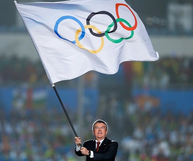 International Olympic Committee (IOC) President Thomas Bach waves the Olympic flag