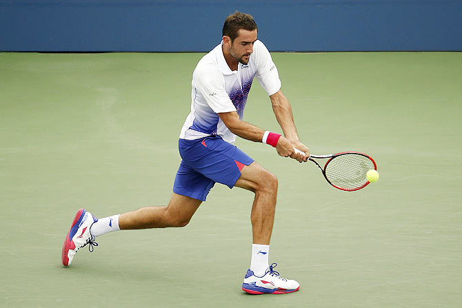 Marin Cilic of Croatia hits a backhand against Mikhail Kukushkin of Kazakhstan during their 3rd round match at the 2015 U.S. Open tennis tournament at USTA Billie Jean King National Tennis Center on Friday
