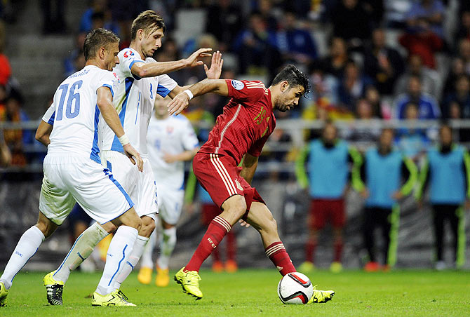 Spain's Diego Costa (right) is challenged by Slovakia's Kornel Salata (left) and Norbert Gyomber
