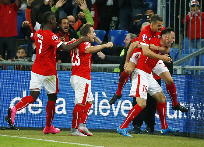 Switzerland's Josip Drmic (right) celebrates with teammates after scoring a goal against Slovenia during their Euro 2016 group E qualification match at the St. Jakob Park stadium in Basel, Switzerland on Saturday