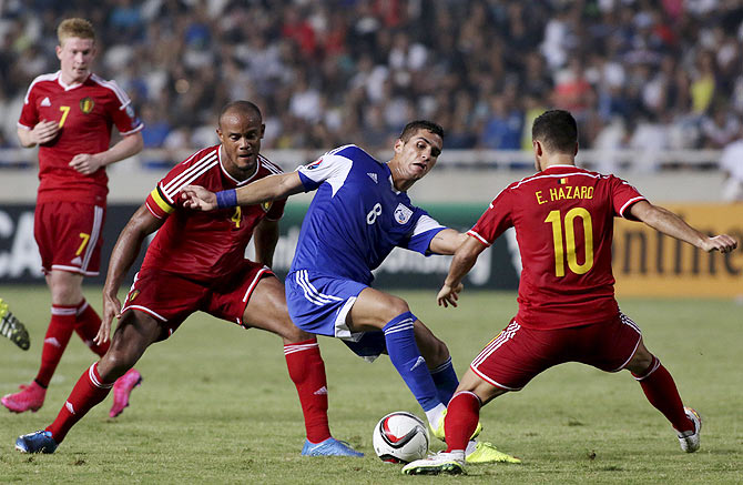 Cyprus' Pieros Sotiriou (centre) is challenged by Belgium's Eden Hazard (right) and Vincent Kompany