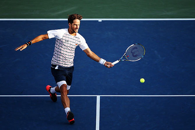 Spain's Feliciano Lopez returns a shot to Italy's Fabio Fognini