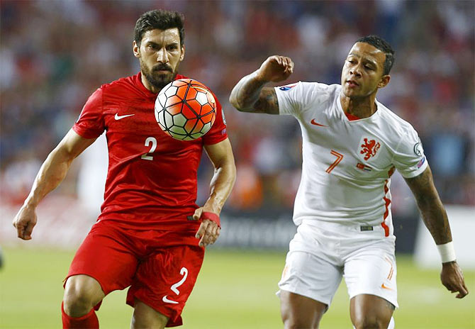 Turkey's Sener Ozbayrakli (L) fights for the ball with Memphis Depay of the Netherlands