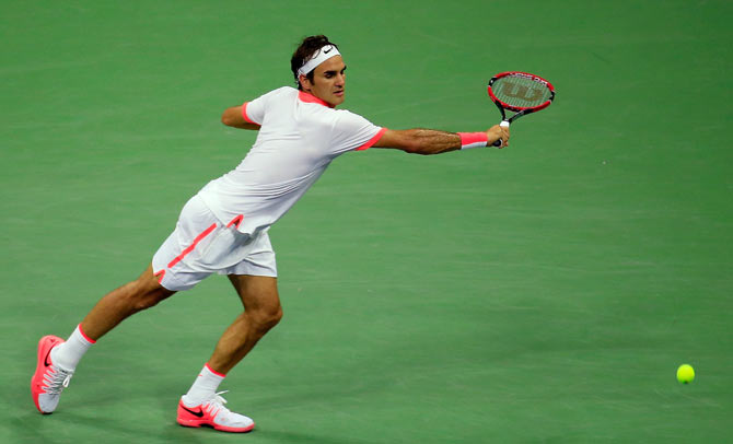 Switzerland's Roger Federer returns a shot against USA's John Isner