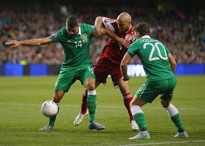 Ireland's Jonathan Walters and Wes Hoolahan battle for the ball against Georgia's Jaba Kankava during their UEFA EURO 2016 Group D qualifying match at Aviva Stadium in Dublin, Ireland, on Monday