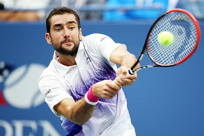 Marin Cilic plays a return against Novak Djokovic