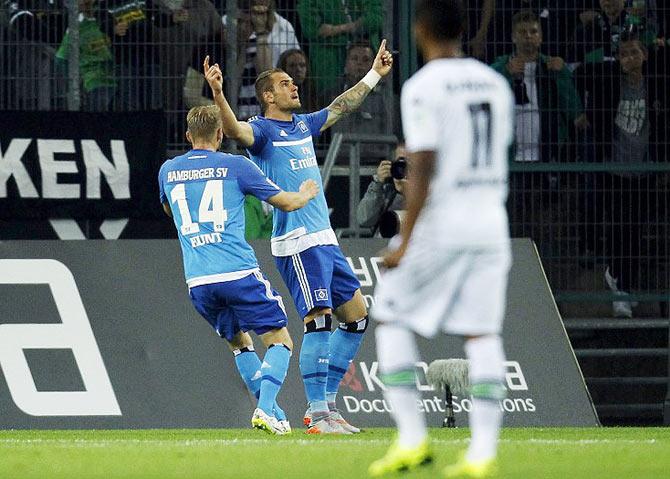 Hamburger SV's Pierre Michel Lasogga (centre) and Aaron Hunt celebrate a goal against Borussia Moenchengladbach during their Bundesliga soccer match in Moenchengladbach, on Friday