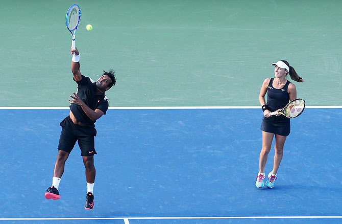 Leander Paes (left) returns a shot as partner Martina Hingis watches during their US Open mixed doubles final against USA's Bethanie Mattek-Sands and Sam Querrey on Friday
