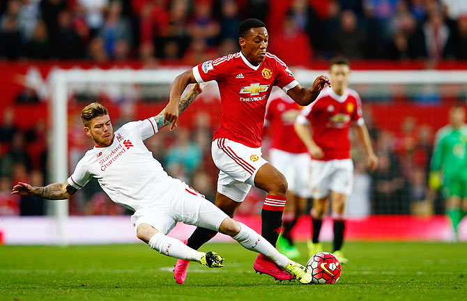 Manchester United's Anthony Martial of is tackled by Liverpool's Alberto Moreno during the English Premier League match at Old Trafford in Manchester on Saturday