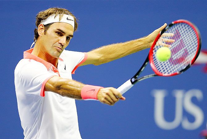 Switzerland's Roger Federer returns a shot to compatriot Stanislas Wawrinka