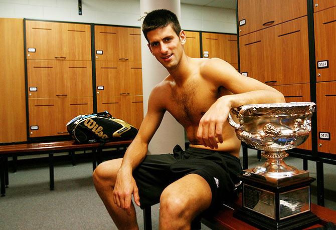 Novak Djokovic poses with the Norman Brookes Challenge Cup in the players' locker room after winning the Australian Open men's final against Jo-Wilfried Tsonga at Melbourne Park on January 27, 2008