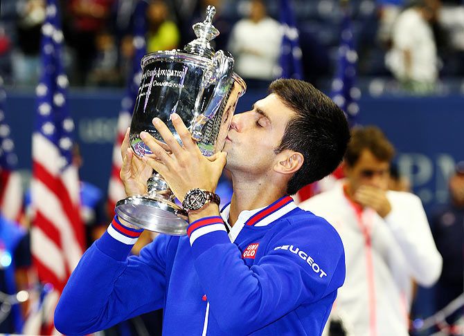Serbia's Novak Djokovic kisses the trophy after defeating Switzerland's Roger Federer to win the US Open final at the USTA Billie Jean King National Tennis Center at the Flushing Meadows on Sunday