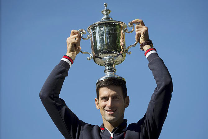 Novak Djokovic of Serbia poses with the champion's trophy in Central Park in New York, a day after winning the US Open Championships men's tennis tournament