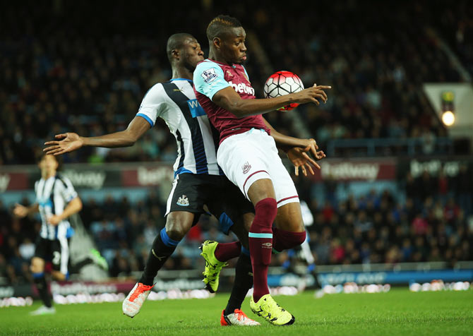 West Ham United's Diafra Sakho (left) is held up by Newcastle United's Chancel Mbemba