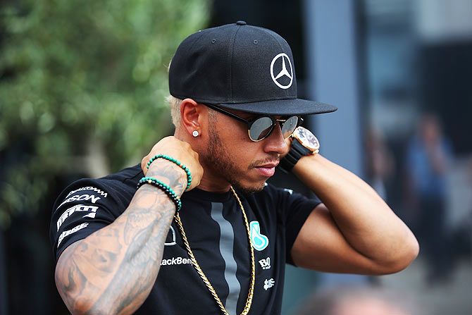 Mercedes GP's British driver Lewis Hamilton looks on in the paddock