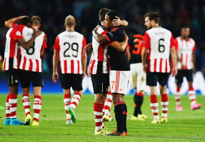 PSV Eindhoven's Santiago Arias hugs Manchester United's Memphis Depay after the match