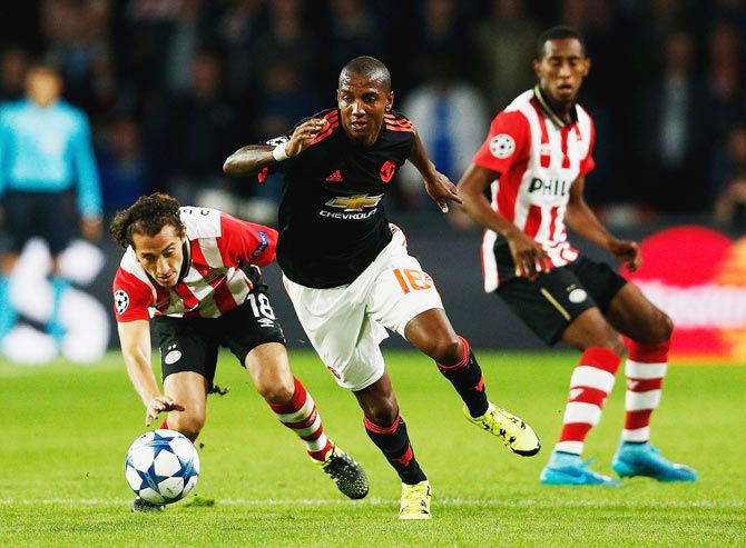 Manchester United's Ashley Young steals the ball away from PSV Eindhoven's Andres Guardado (left)