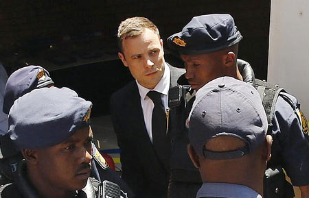 South African Olympic and Paralympic sprinter Oscar Pistorius (centre) is escorted to a police van after his sentencing at the North Gauteng High Court in Pretoria on October 21, 2014