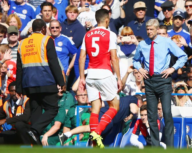 Arsenal's Gabriel walks off the pitch in front of head coach Arsene Wenger after being shown the red card during their Barclays Premier League match against Chelsea at Stamford Bridge on Saturday