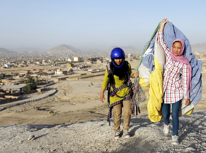Zakia Mohammadi, 21, (R) walks with Leeda Ozori, 21, after paragliding exercise