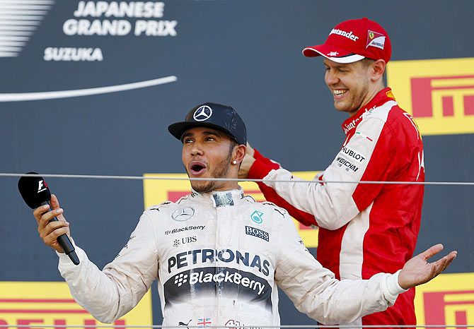 Ferrari's Sebastian Vettel (right) pours champagne over Mercedes' Lewis Hamilton, after the Japanese F1 Grand Prix at the Suzuka circuit in Suzuka on Sunday