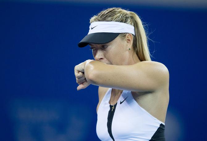 Russia's Maria Sharapova wipes her face as she plays against Czech Republic's Barbora Strycova during their women's singles match at the Wuhan Open tennis tournament, in Hubei province, China, on Monday