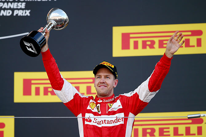 Germany and Ferrari's Sebastian Vettel celebrates on the podium after finishing third in the Formula One Grand Prix of Japan at Suzuka Circuit in Suzuka on Sunday