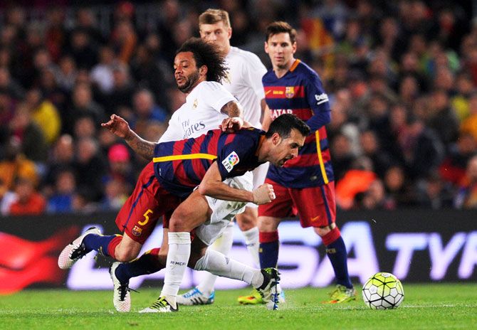 FC Barcelona's  Sergio Busquets battles for the ball with Real Madrid's Marcelo