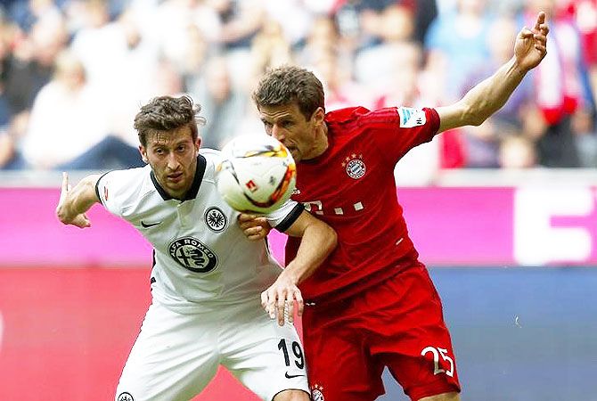 Eintracht Frankfurt's David Abraham and Bayern Munich's Thomas Mueller vie for possession during their Bundesliga match at the Allianz-Arena in Munich on Saturday, April 2.