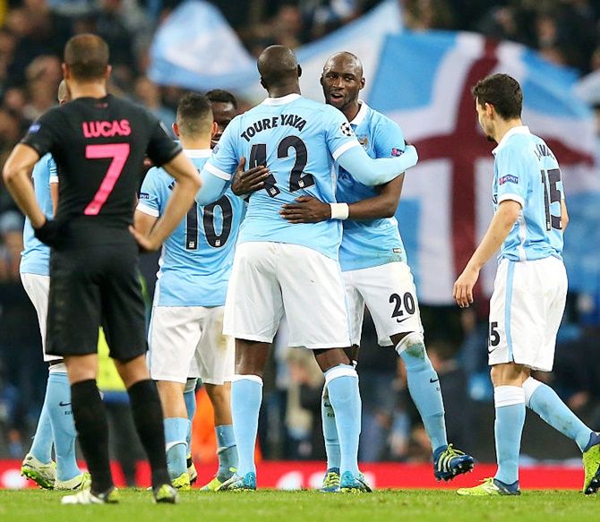 Manchester City’s Eliaquim Mangala (20), Yaya Toure and Jesus Navas celebrate victory after reaching the semi-finals after the Champions League