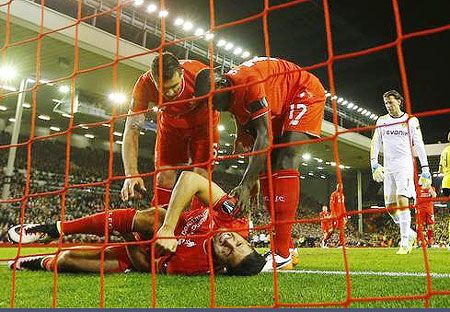 Liverpool's Emre Can lies on the goal line after sustaining an injury 