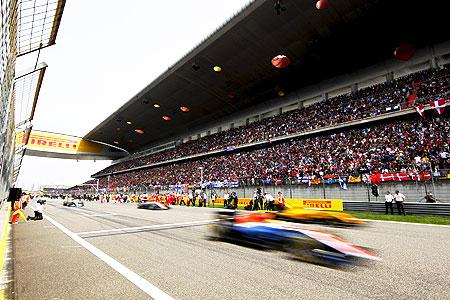 Racers drive past the grandstand during the warm-up lap of the Chinese Grand Prix