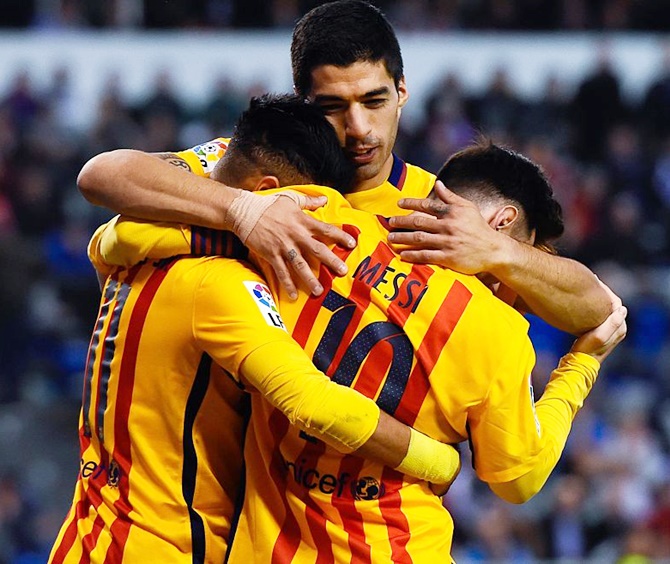 Luis Suarez of FC Barcelona embraces his team mates Neymar, left, and Lionel Messi after Neymar scored his team's eighth goal against Deportivo on Wednesday