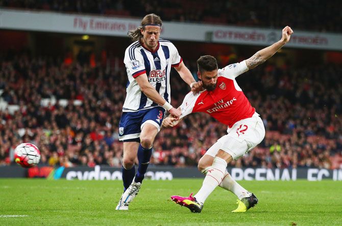 Arsenal's Olivier Giroud shoots as he is challenged by West Bromwich Albion's Jonas Olsson