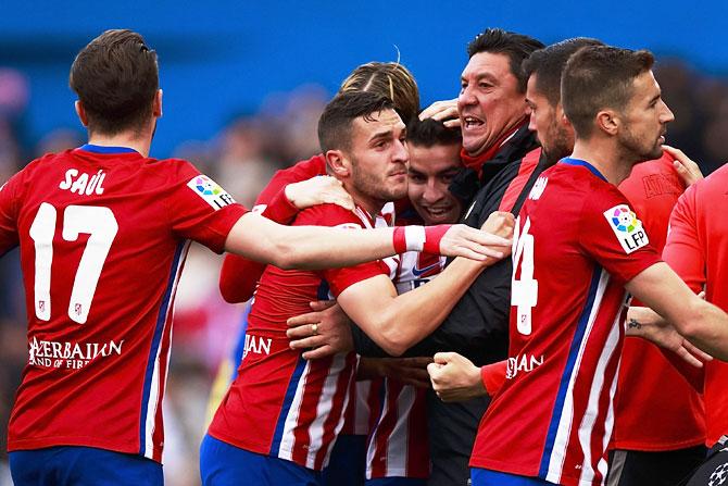 Atletico de Madrid's Angel Martin Correa (3rd from left) celebrates scoring against Malaga CF with assistant coach German Burgos and teammates at Vicente Calderon Stadium