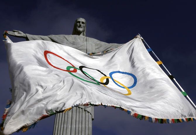 The Olympic Flag flies in front of Christ the Redeemer in Rio de Janeiro