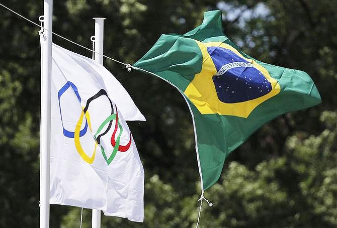 The Olympic and the Brazilian flag fly over the site of ancient Olympia during the Olympic flame lighting ceremony for the Rio 2016 Olympic Games