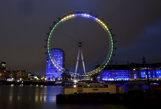 The London Eye is pictured lit in the yellow, green and blue colours of Brazil's flag in celebration of the 100 days before the 2016 Rio Olympics